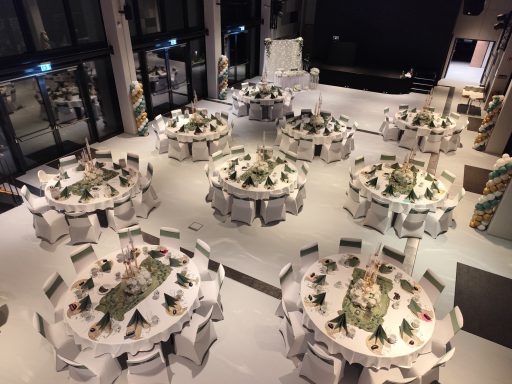 Saaldekoration Hochzeit in Sulzbach an der Murr bei Planet Blue Festsaal mit edel dekorierten runden Tischen und weiĂźen Stuhlhussen fĂĽr eine Hochzeitsfeier.
