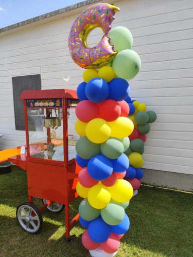 Stylischer roter Popcornwagen im Retro-Design mit bunter Ballon-Deko für Gartenparty