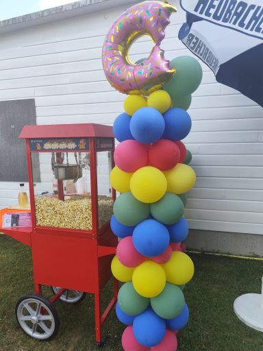 Ballonsäulen & Event-Deko mieten Welzheim Farbenfrohe, meterhohe Luftballonsäule mit einem riesigen aufblasbaren Donut als Partydekoration.