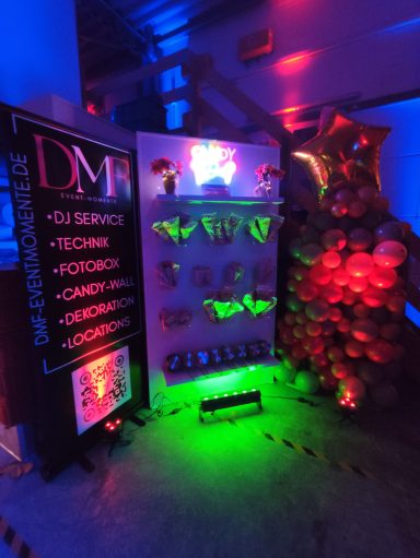 Professioneller Hochzeits-DJ und Eventtechnik buchen Professionelles DJ-Pult von DMF Event-Momente mit leuchtender LED-Fassade und Moving-Heads im Hintergrund.