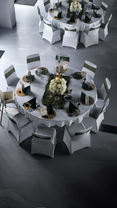 Tischdeko fĂĽr Events mieten Backnang Eingedeckter runder Galatisch mit modernen grauen Akzenten und elegantem Blumenschmuck.